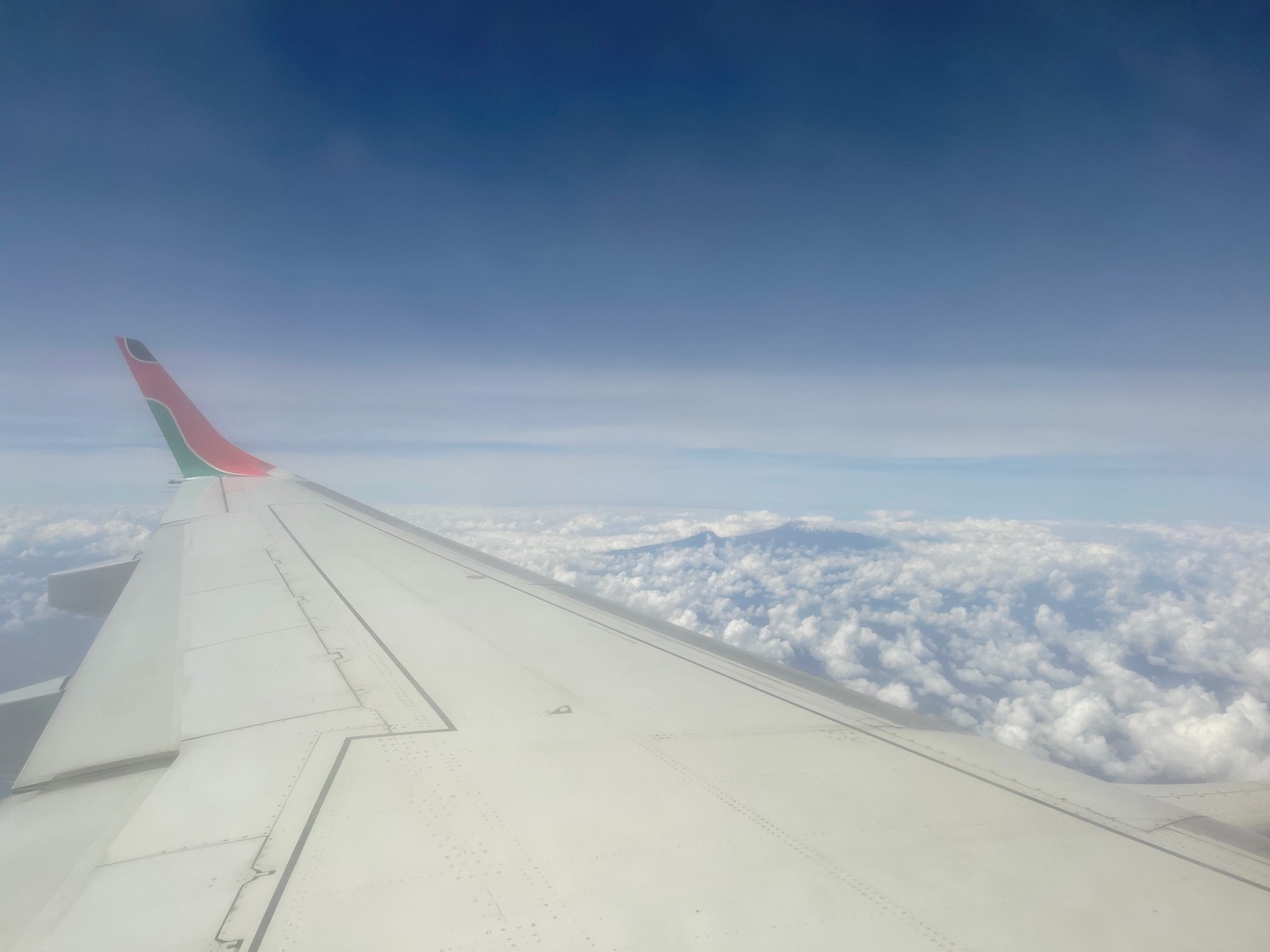 an airplane wing with clouds in the background