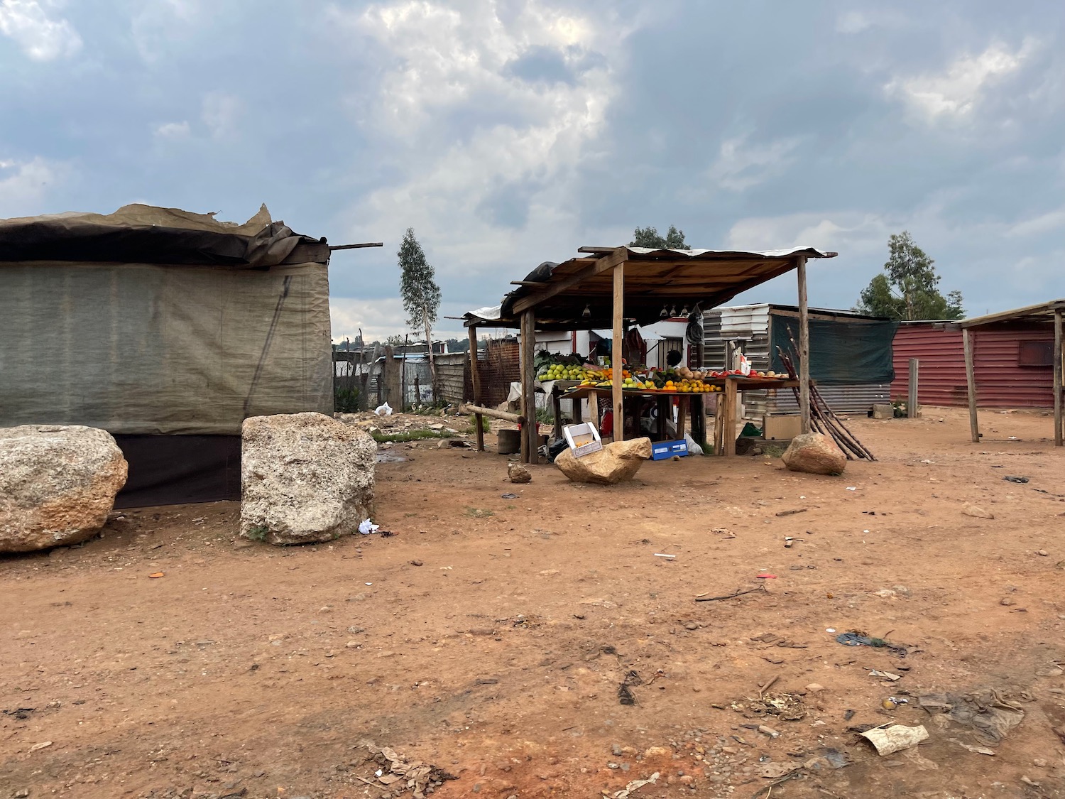 a small shacks and a small table in a dirt area