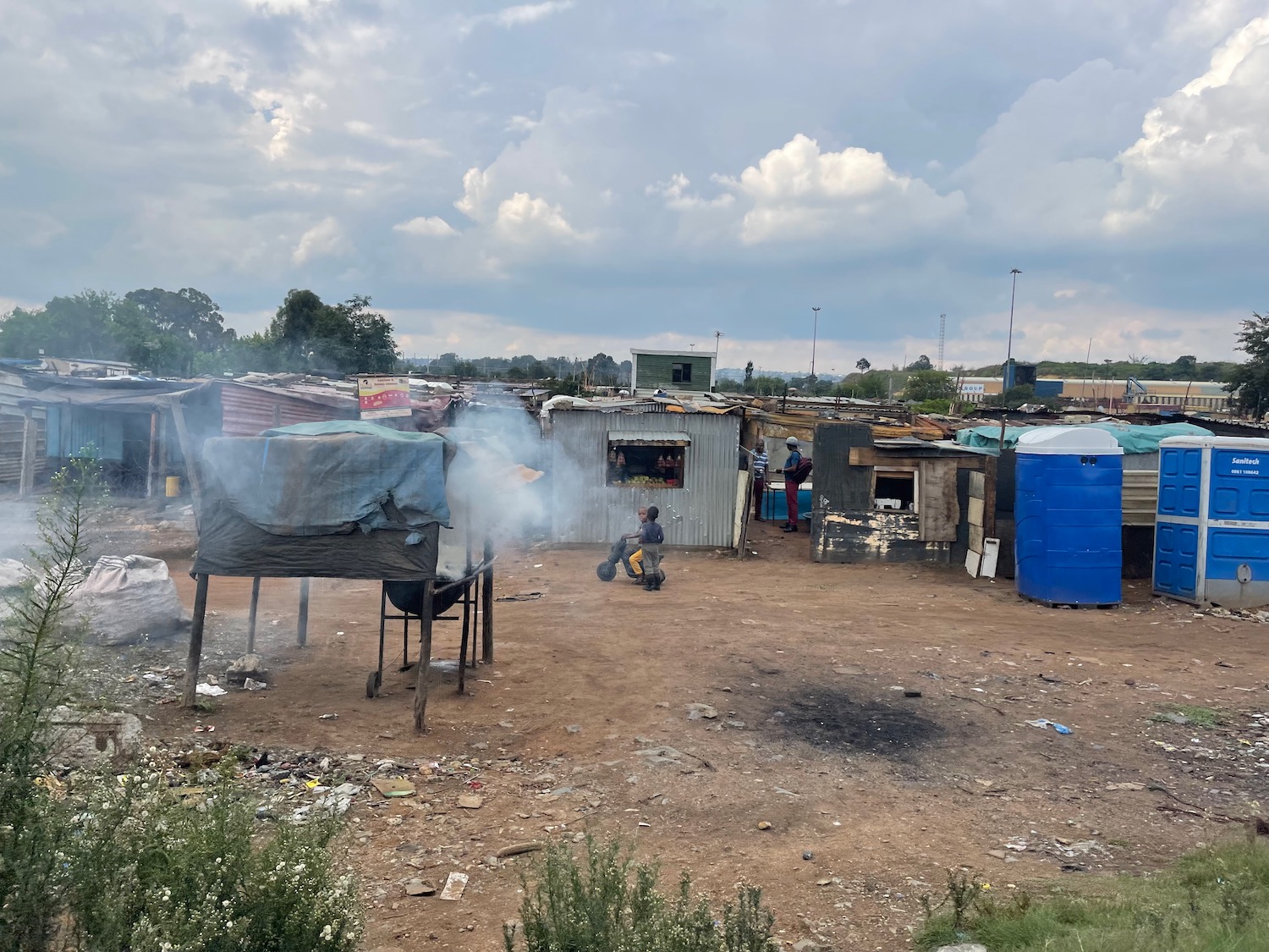 a group of people in a small area with a group of shacks