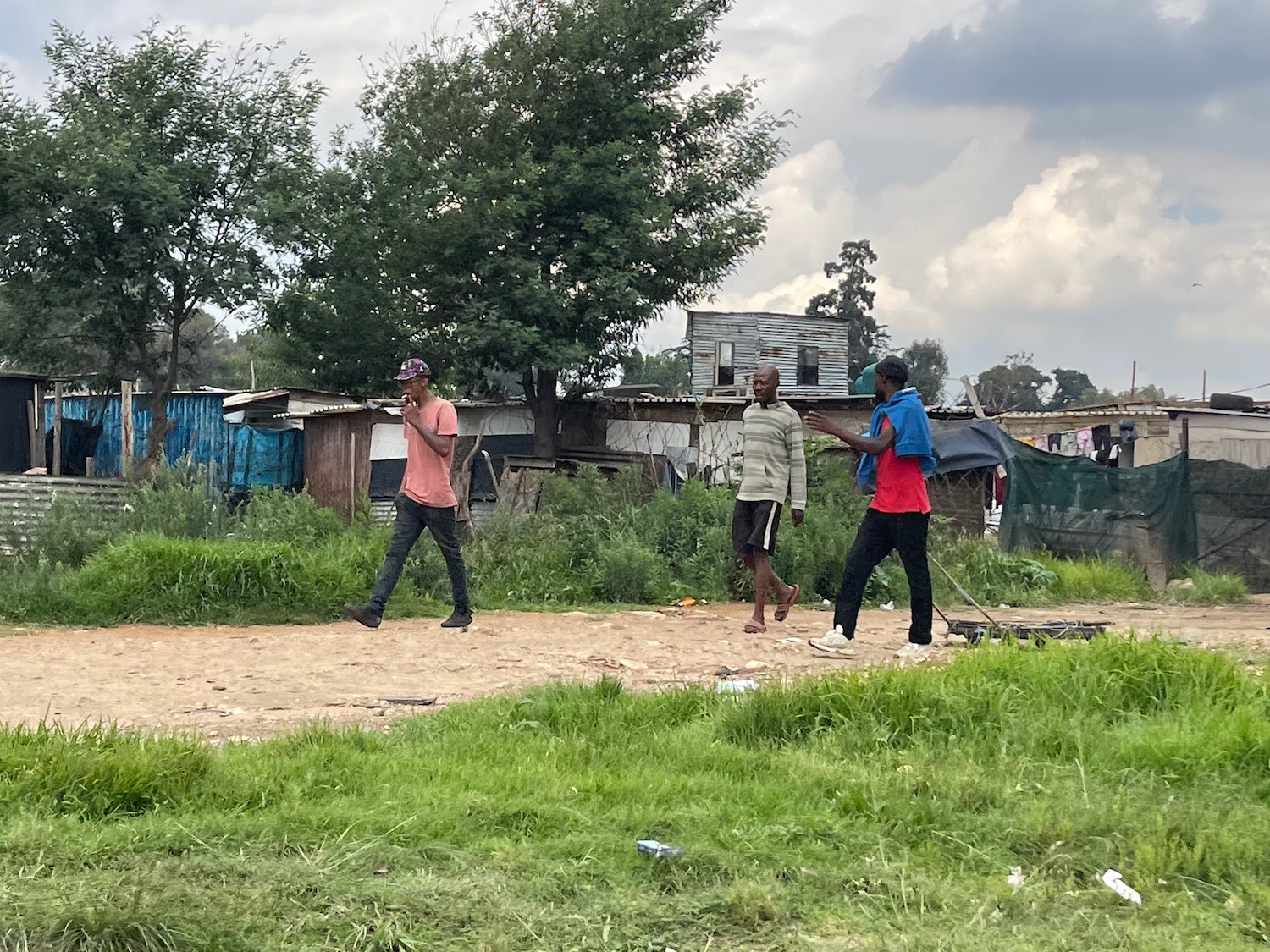 a group of men walking on a dirt road