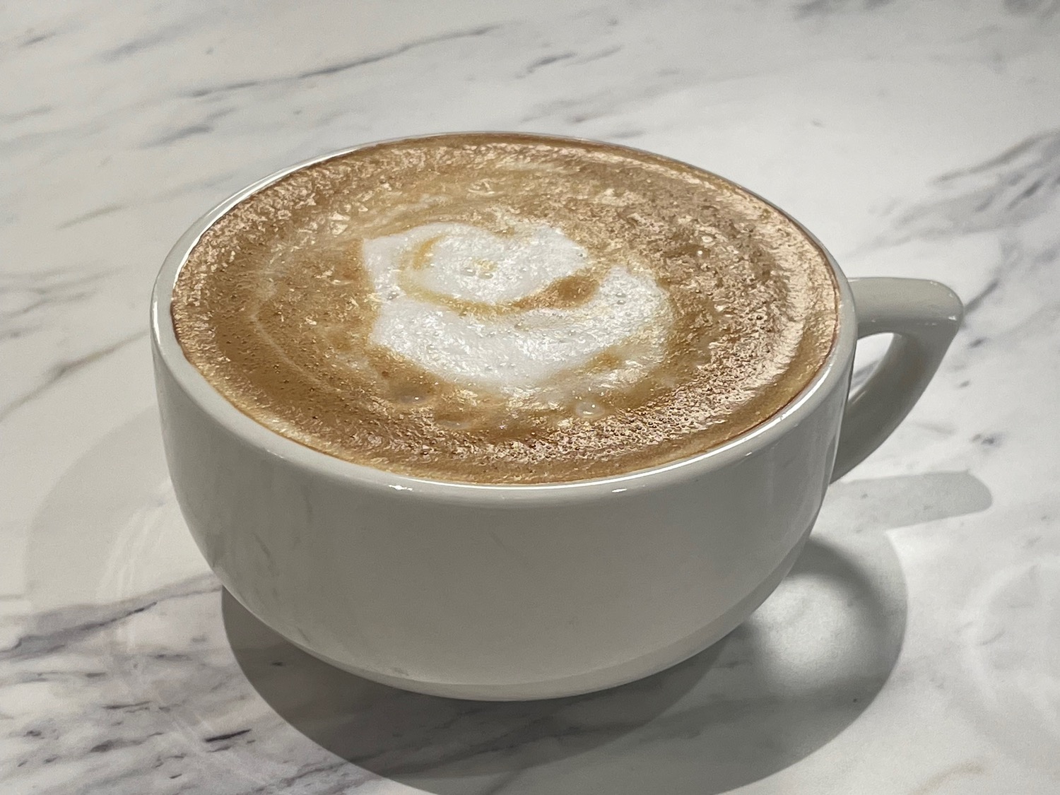 a cup of coffee with a heart shape foam in it