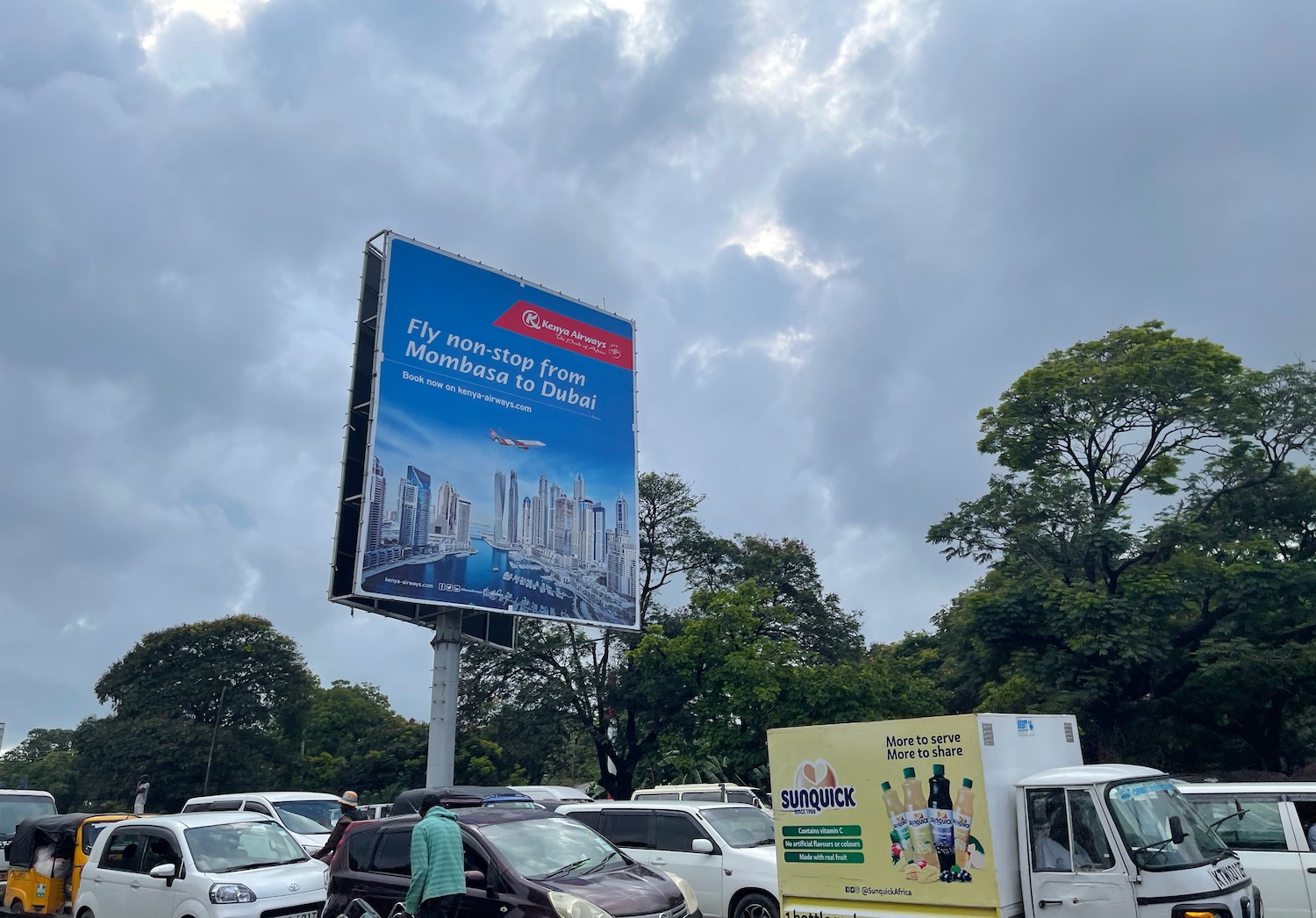 a billboard with a group of cars parked in front of it
