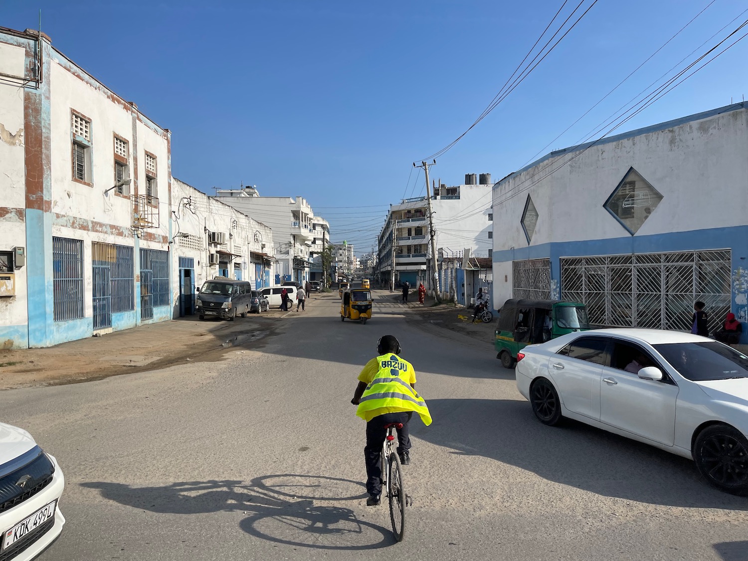 a person riding a bicycle on a street with cars and buildings