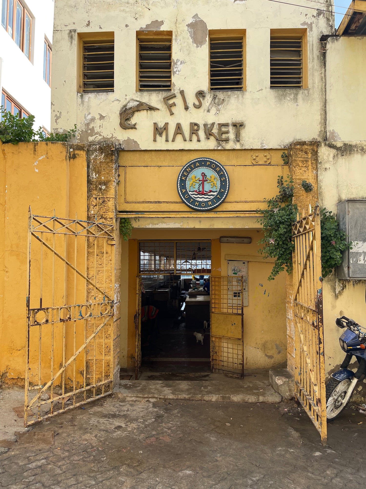 a yellow building with a sign and a motorcycle parked in front of it