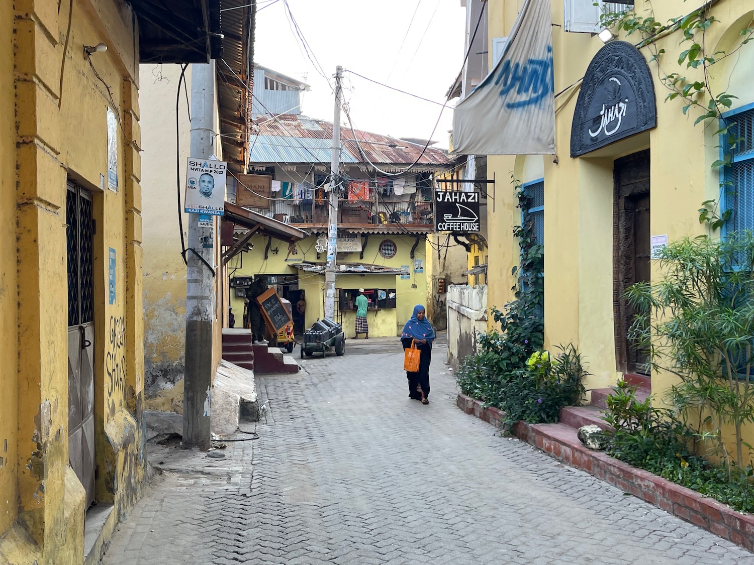 a woman walking down a narrow street