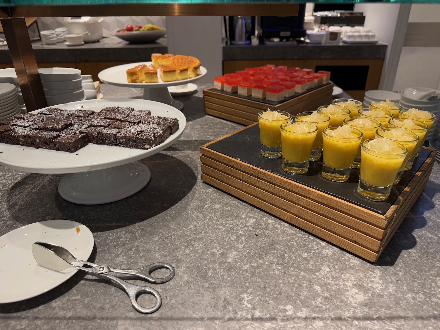 a table with plates of desserts and glasses of orange liquid