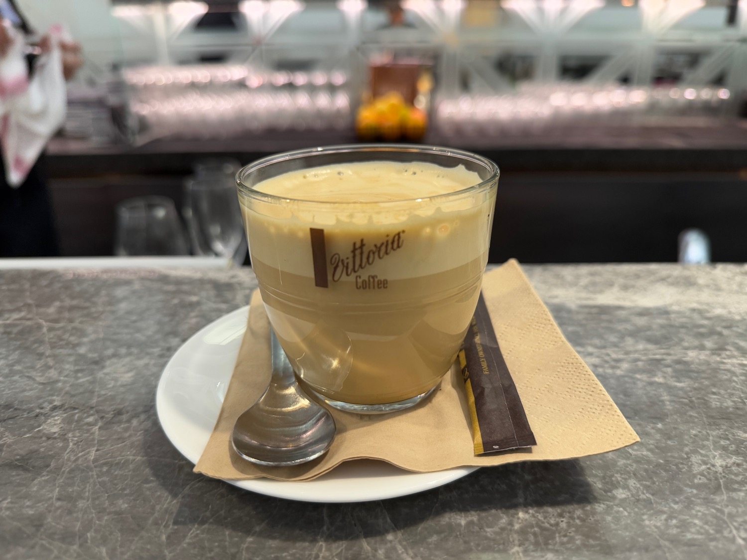 a glass cup with a spoon on a plate