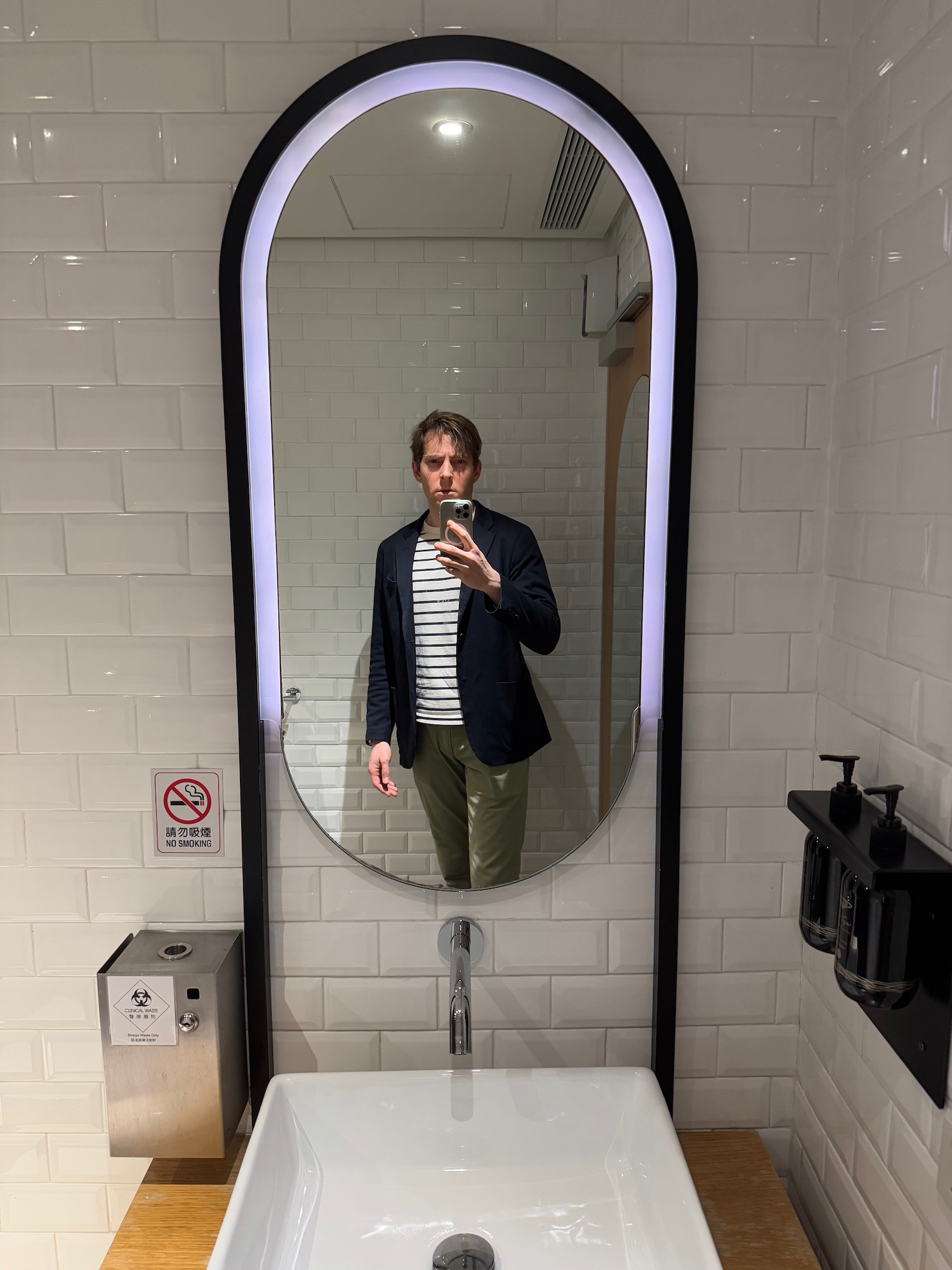 a man taking a selfie in a bathroom mirror