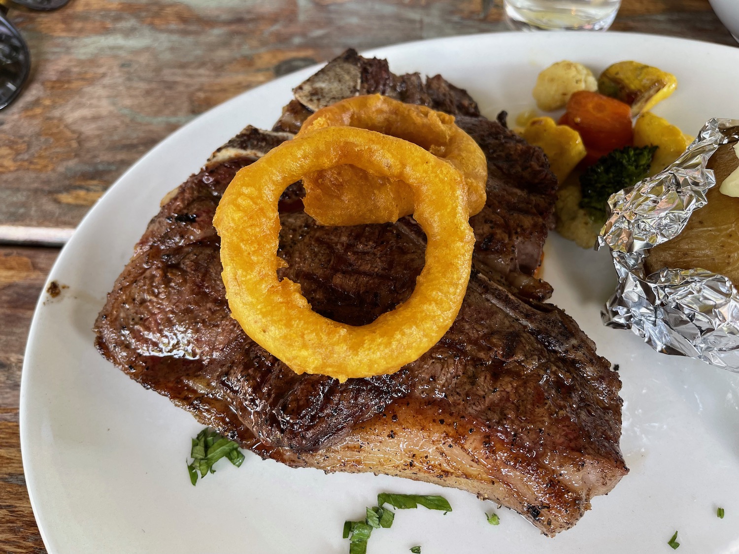 a plate of food with onion rings on top