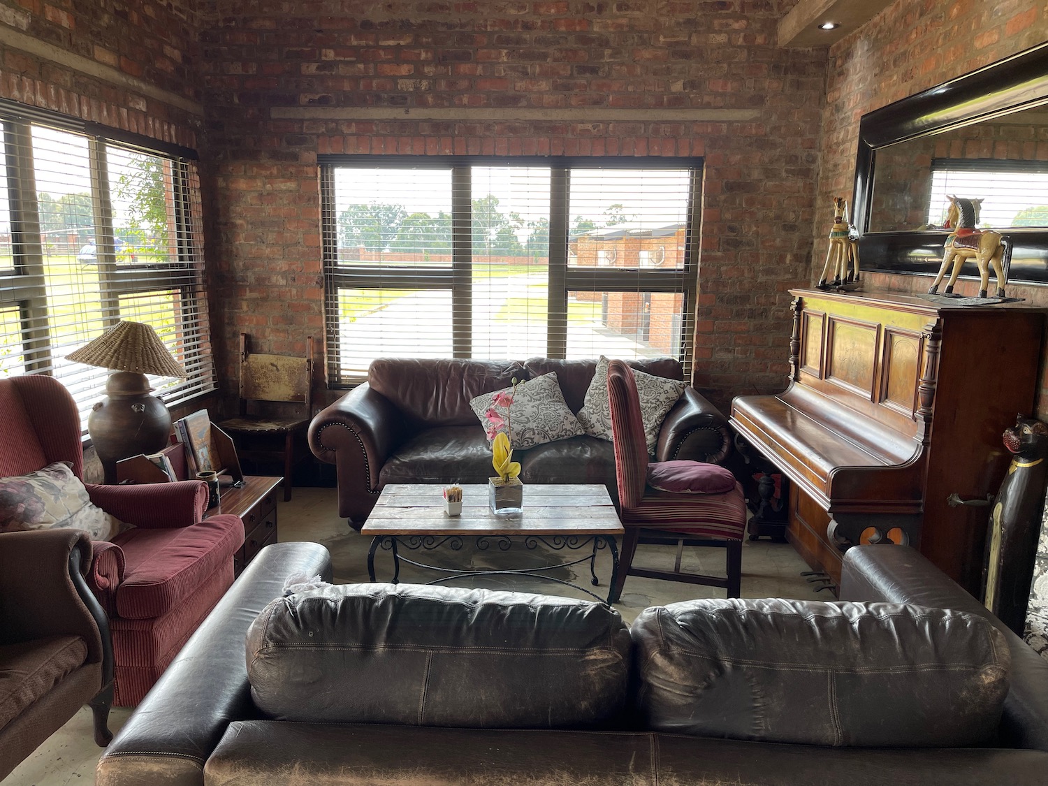 a living room with a piano and couches