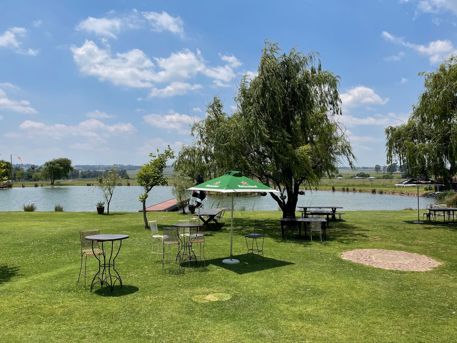 a picnic area with tables and chairs and a lake
