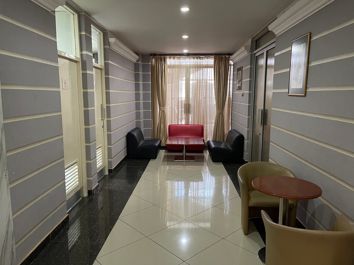 a hallway with chairs and a red couch