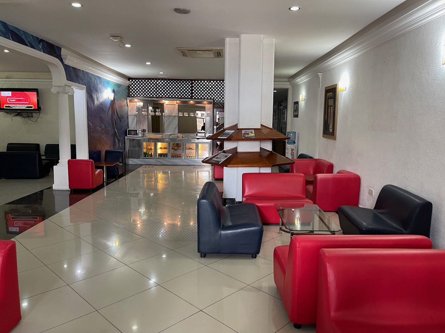 a room with red and blue chairs and a white tile floor