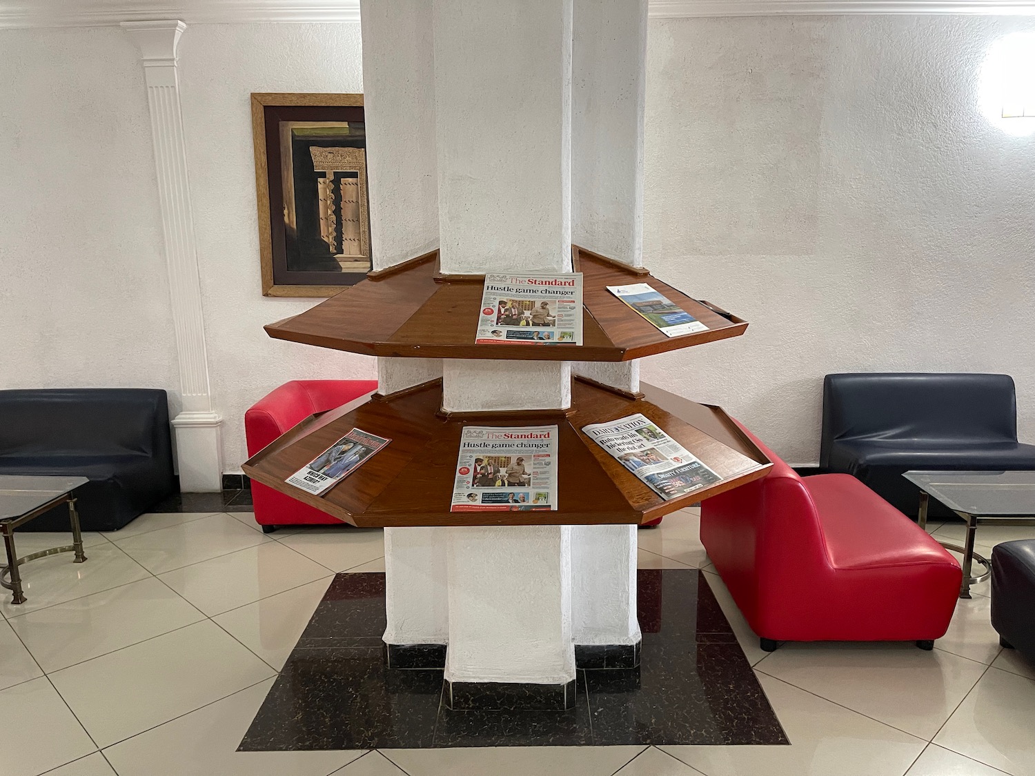 a shelf on a column with a red and black chair