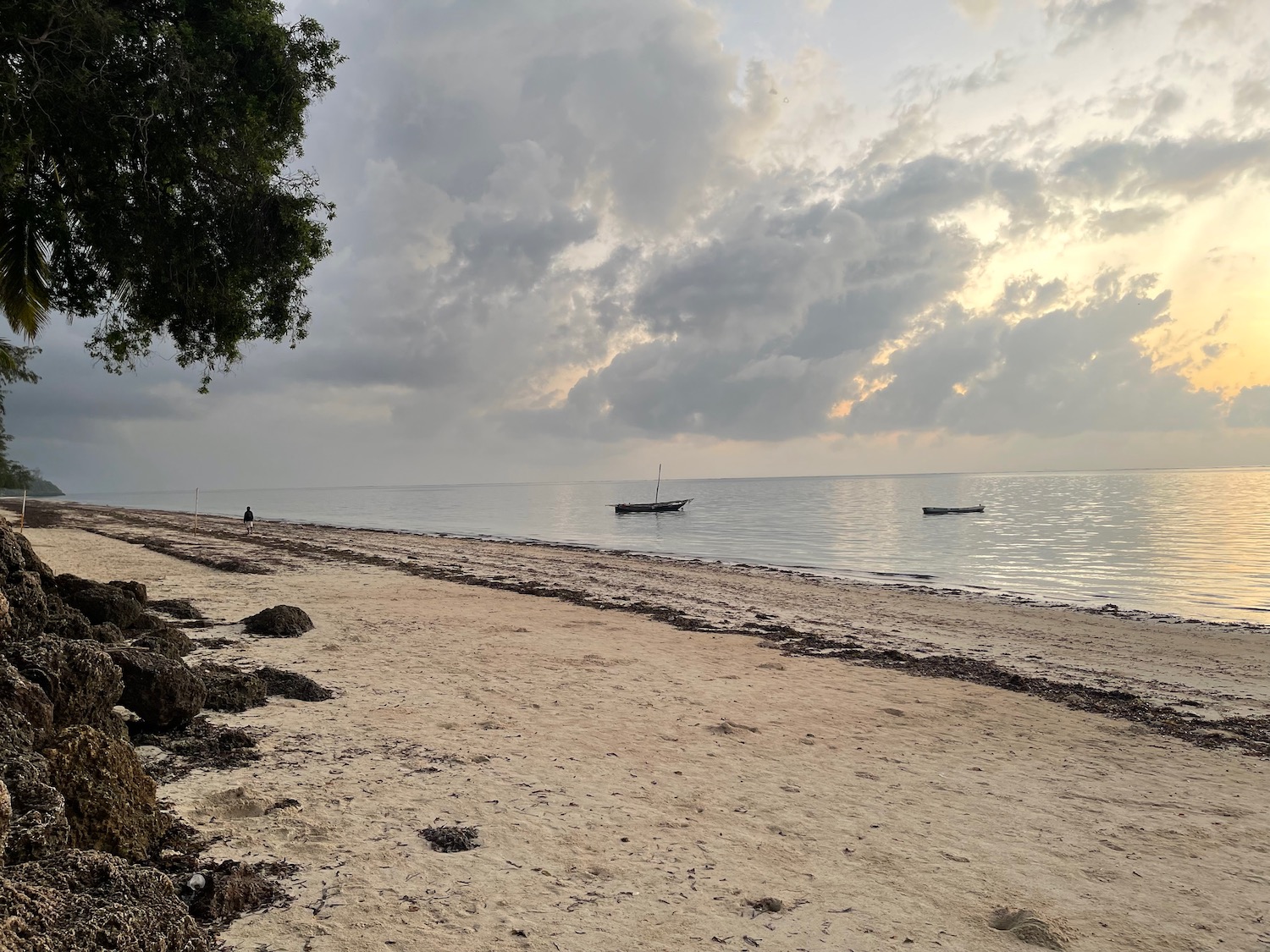 a beach with boats on the water