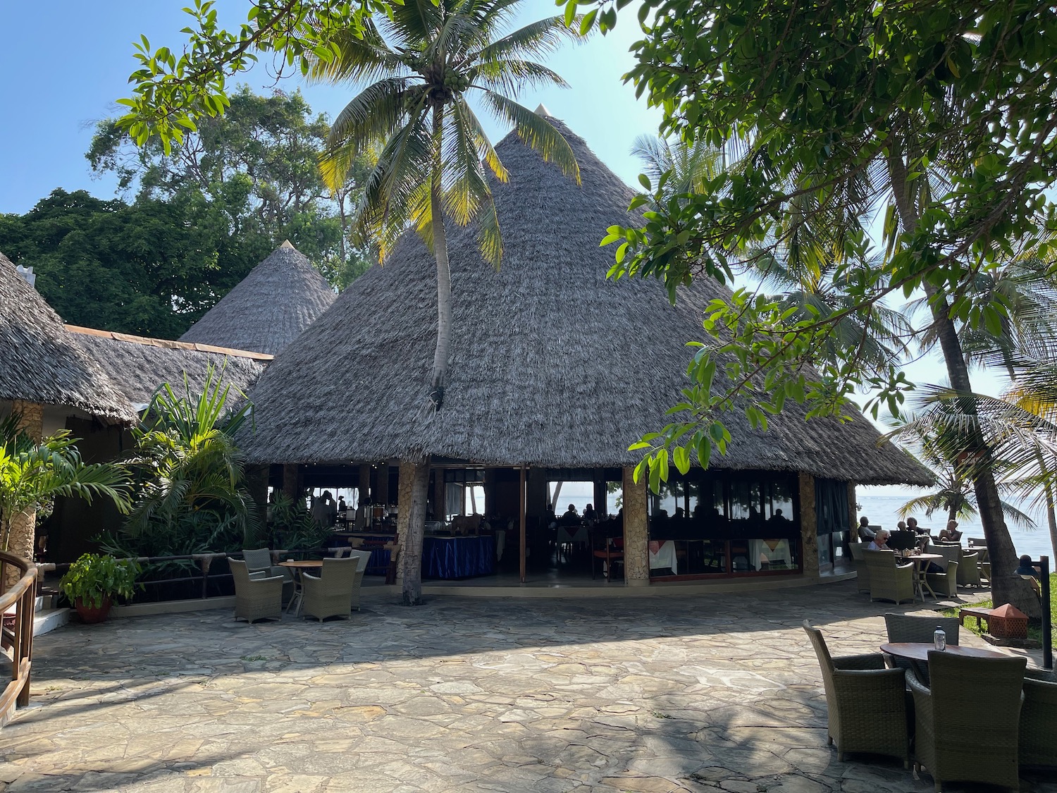 a building with a thatched roof and tables and chairs