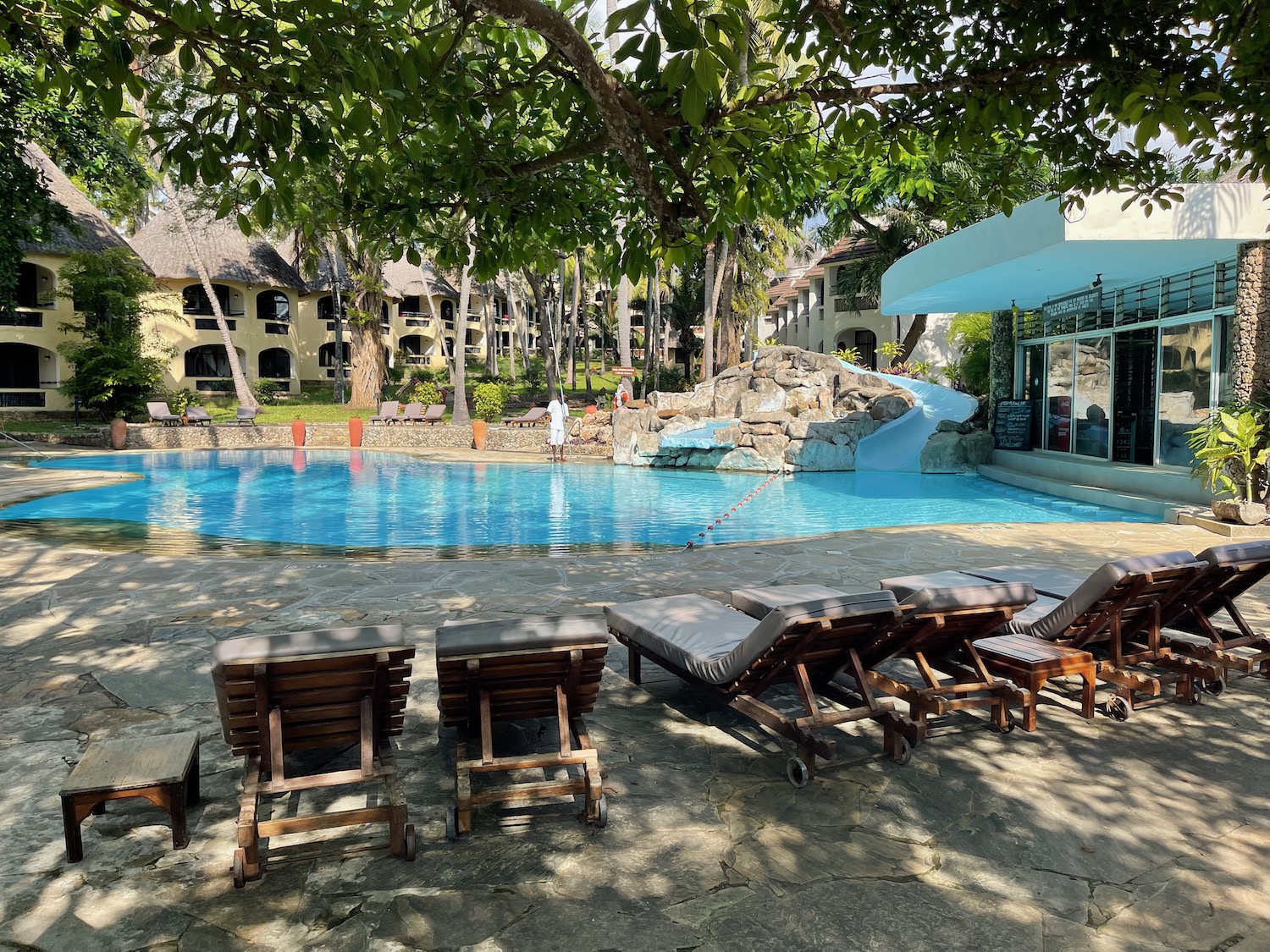 a pool with lounge chairs and a slide