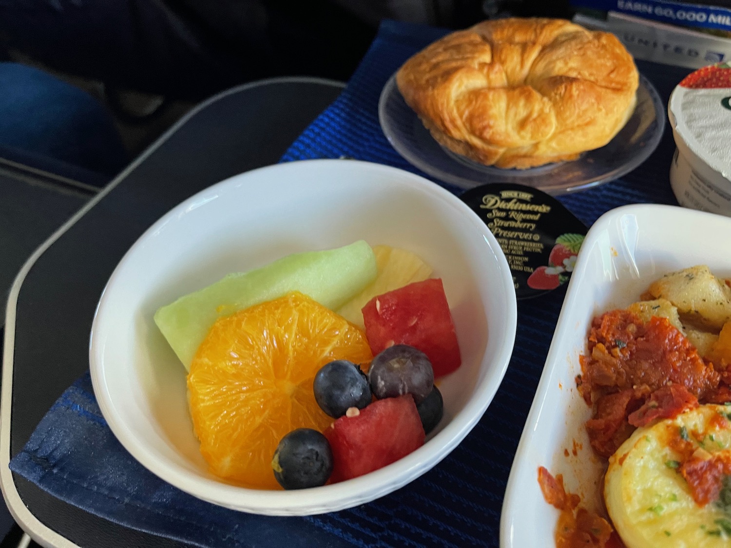 a bowl of fruit and a pastry on a table