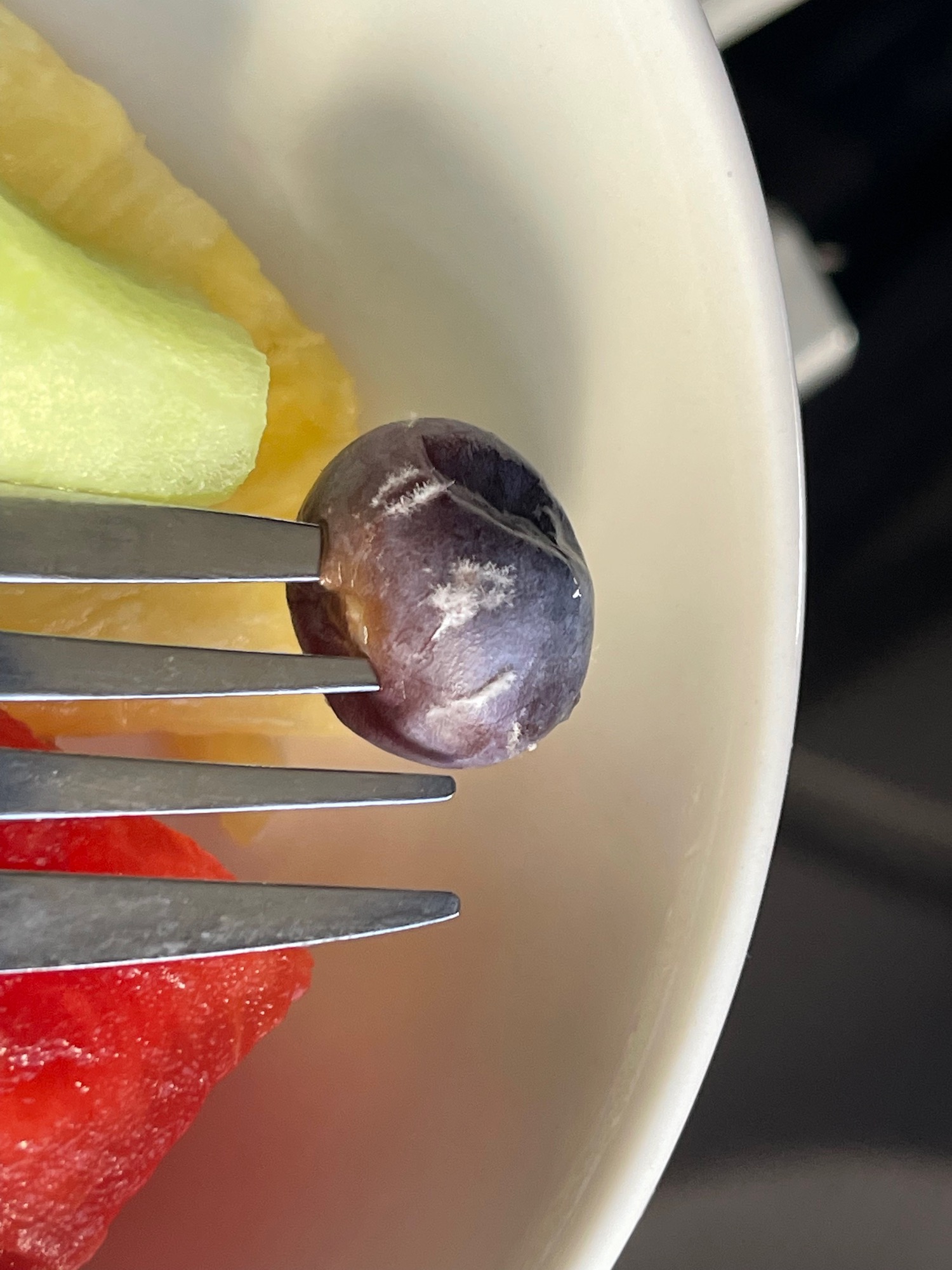 a fork on a plate of fruit