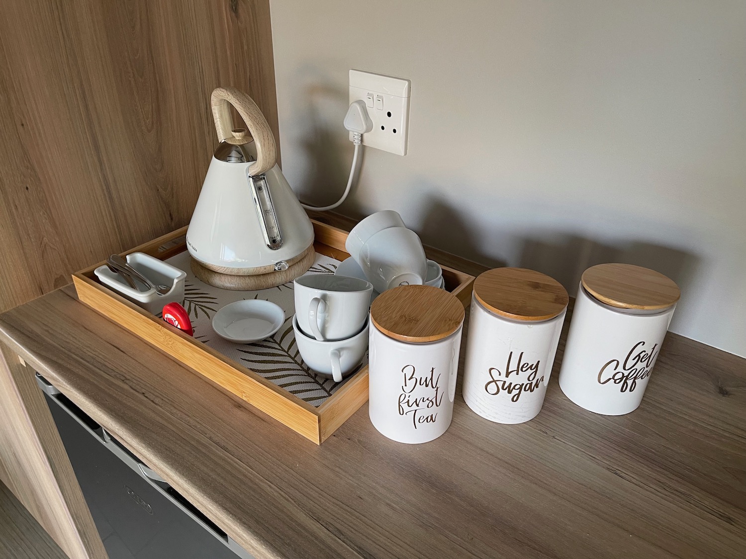 a tray of white coffee cups and teapots on a counter
