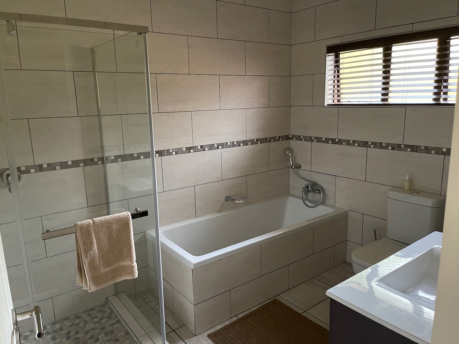 a bathroom with a glass shower door and bathtub