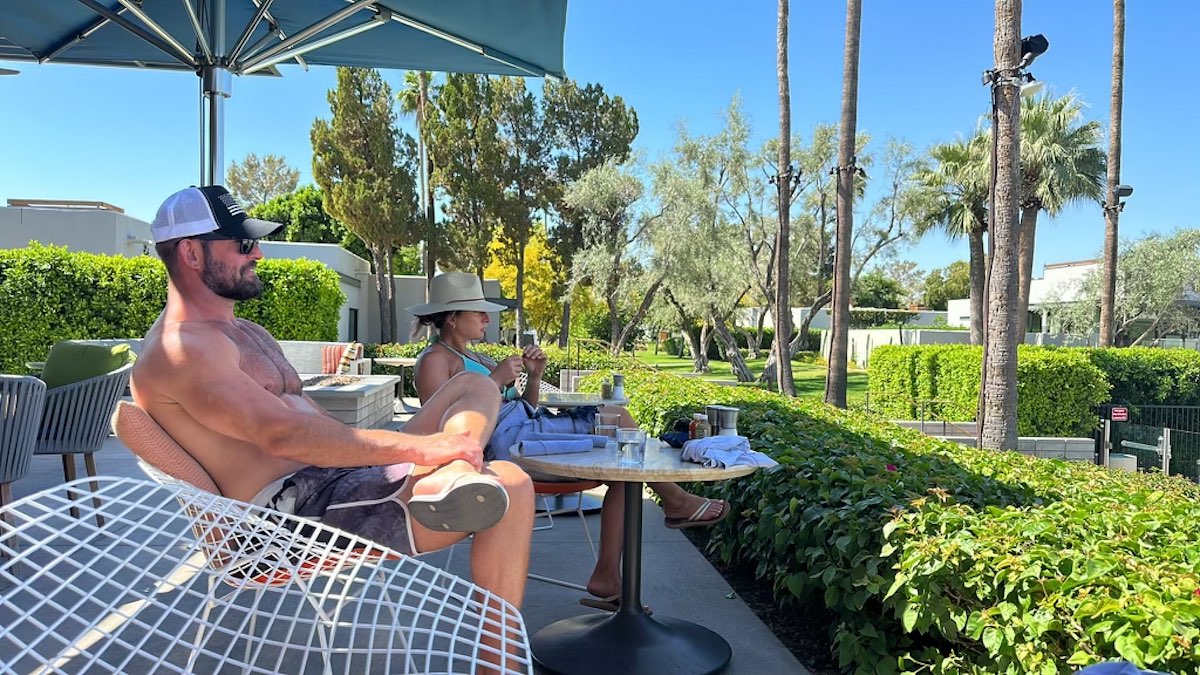 a man and woman sitting at a table outside