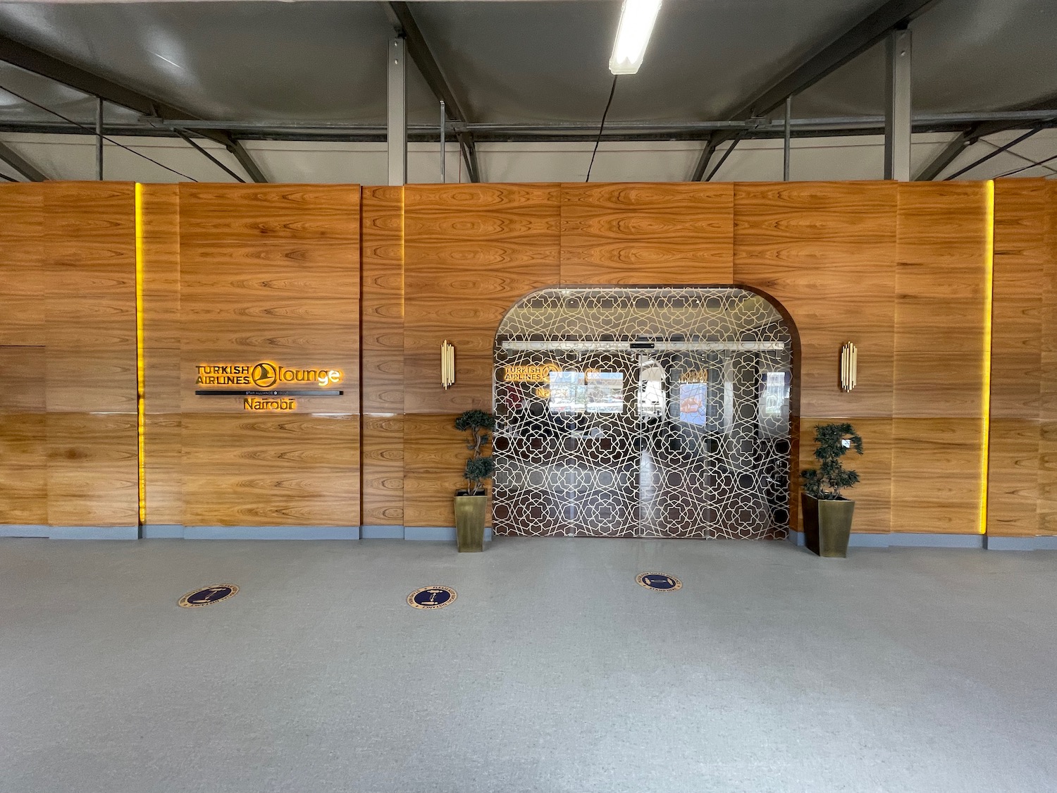 a wood wall with a door and plants