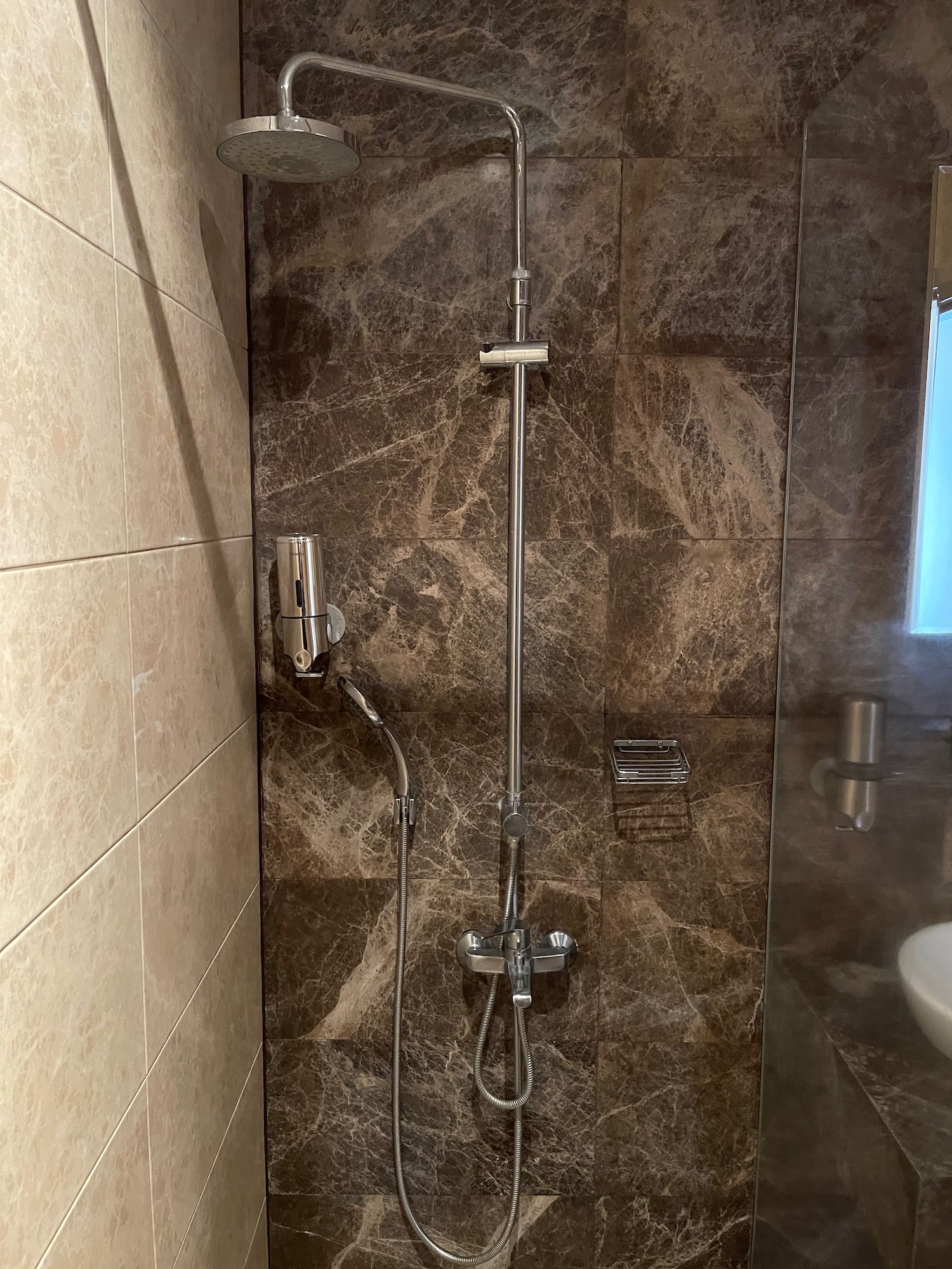 a shower with a shower head and a toilet