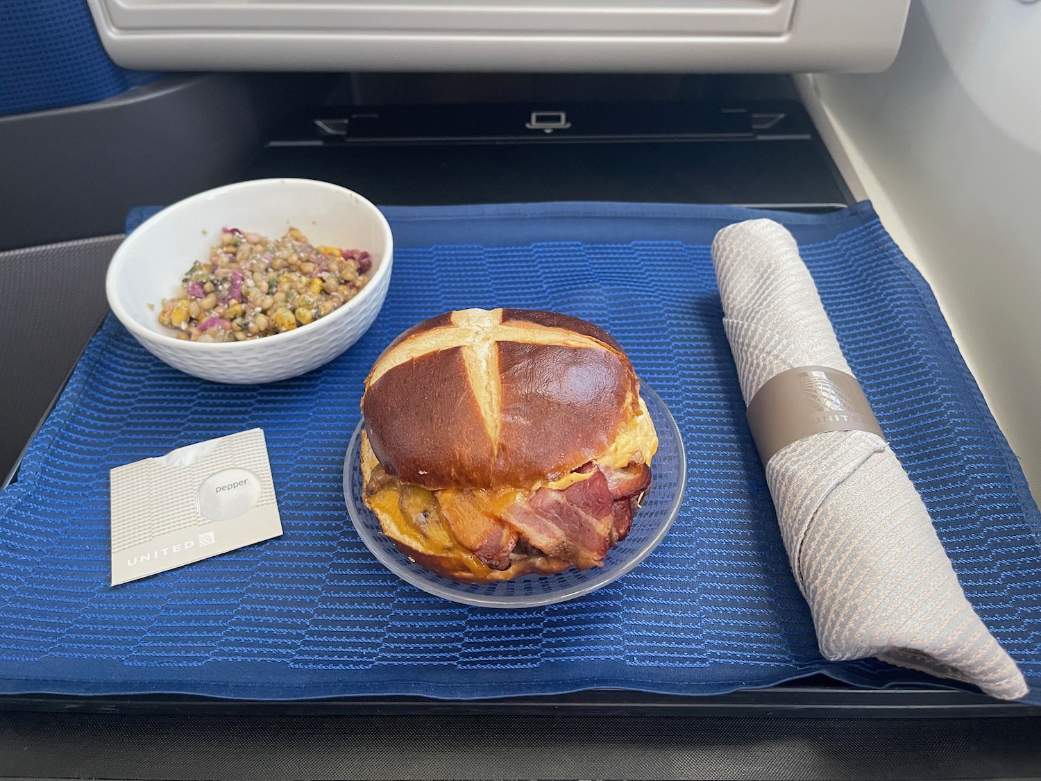 a sandwich and a bowl of cereal on a blue place mat