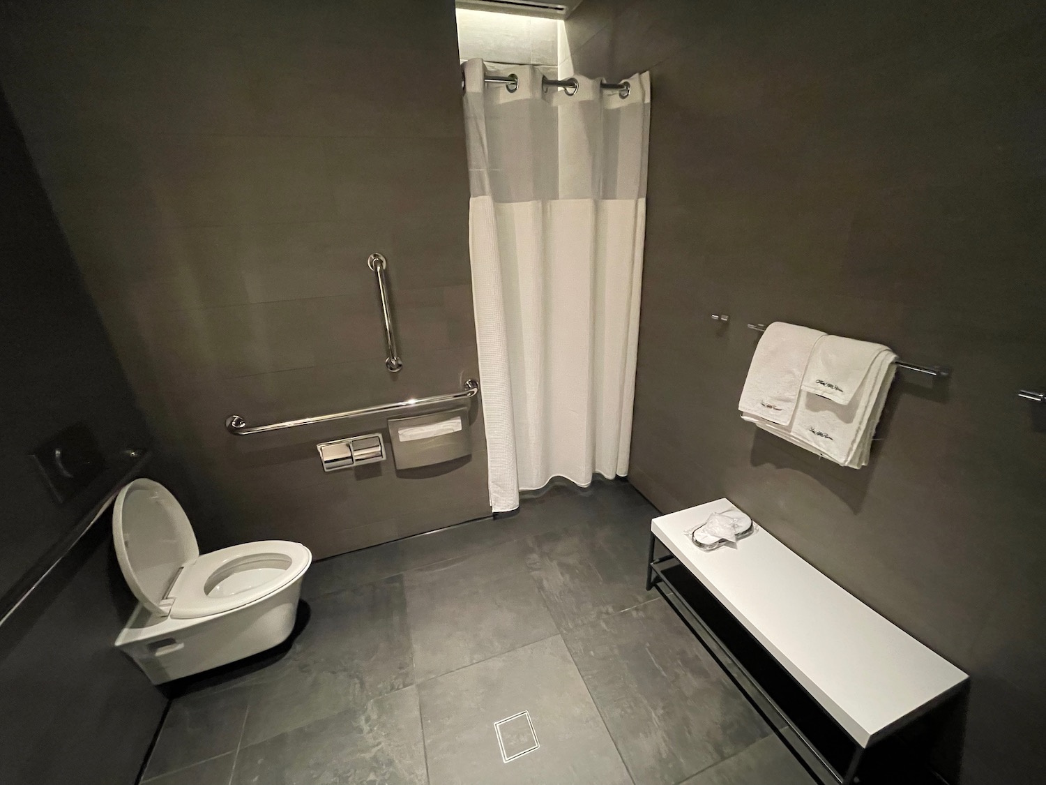 a bathroom with a bench and toilet