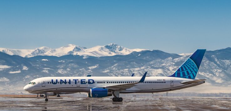 a plane on a runway with mountains in the background