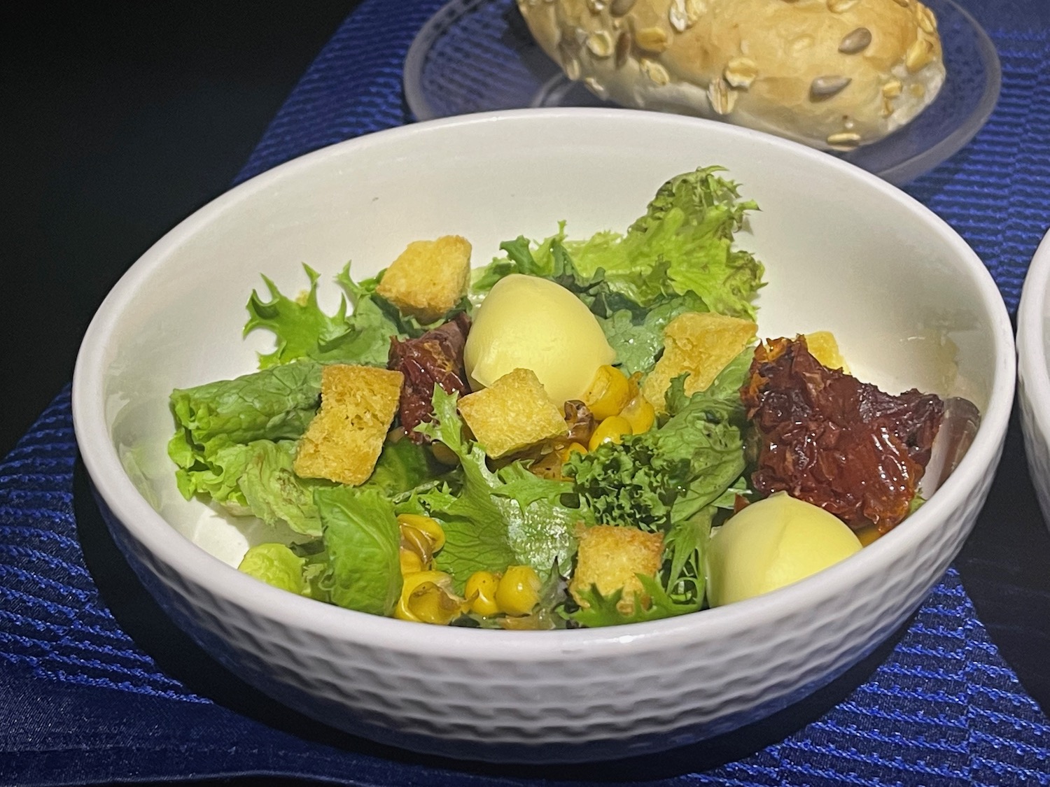 a bowl of salad with a piece of bread