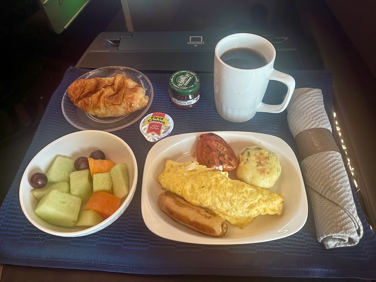a plate of food and a cup of coffee on a tray