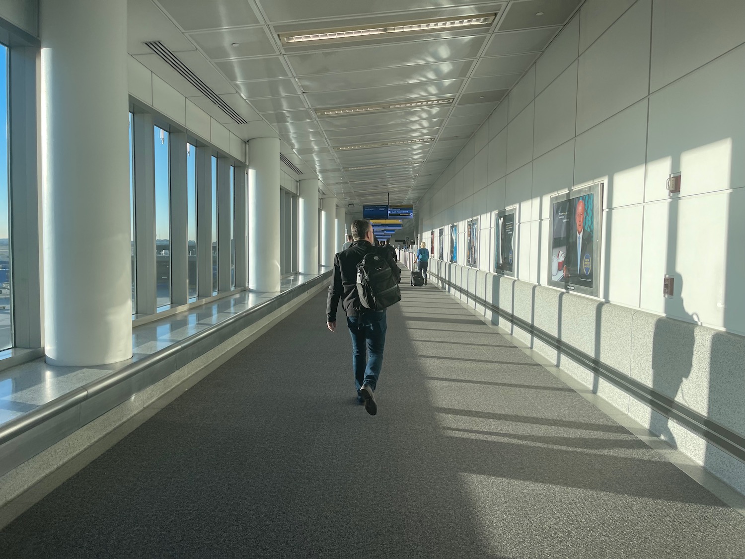 a man walking down a hallway with a backpack