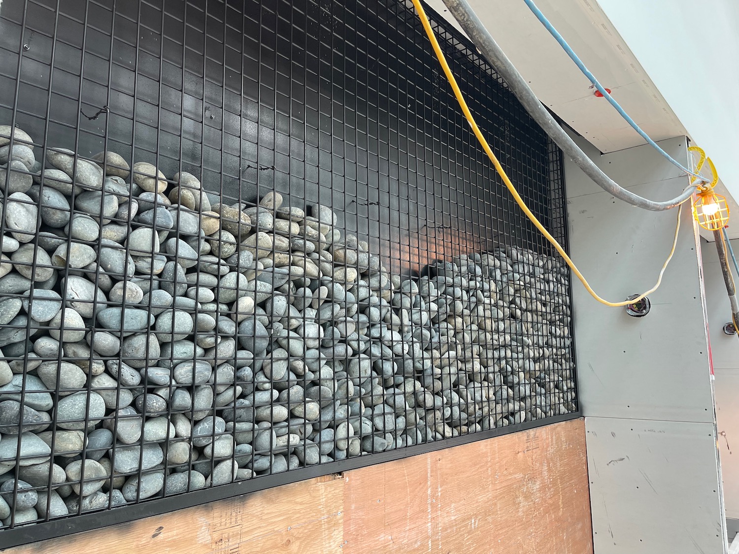 a wall with a wire mesh and a group of rocks