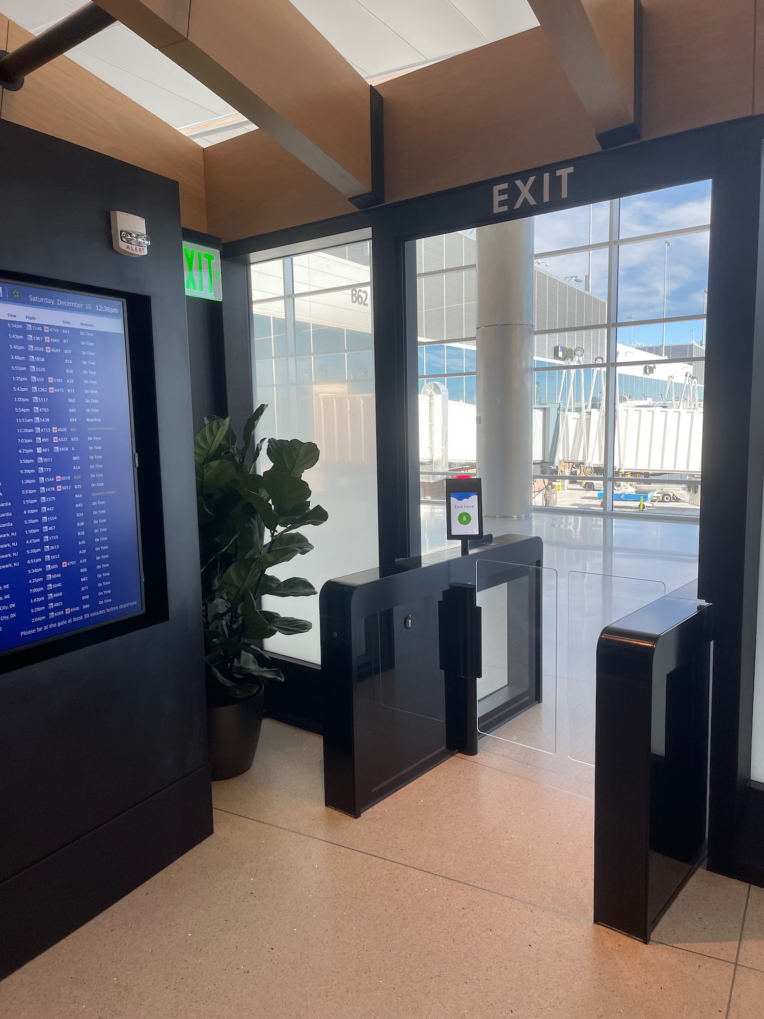 a black exit door with a screen and a plant in front of it