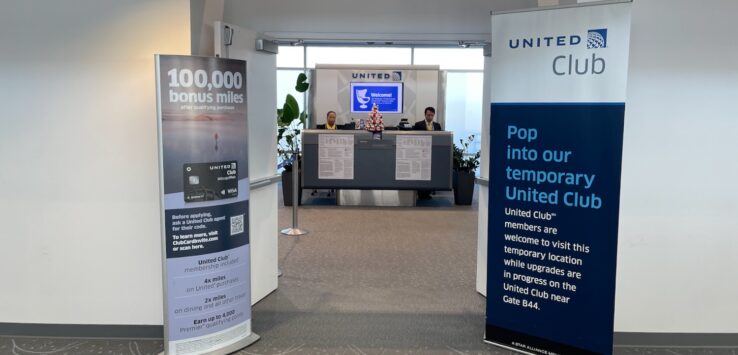 a man at a desk in front of a sign