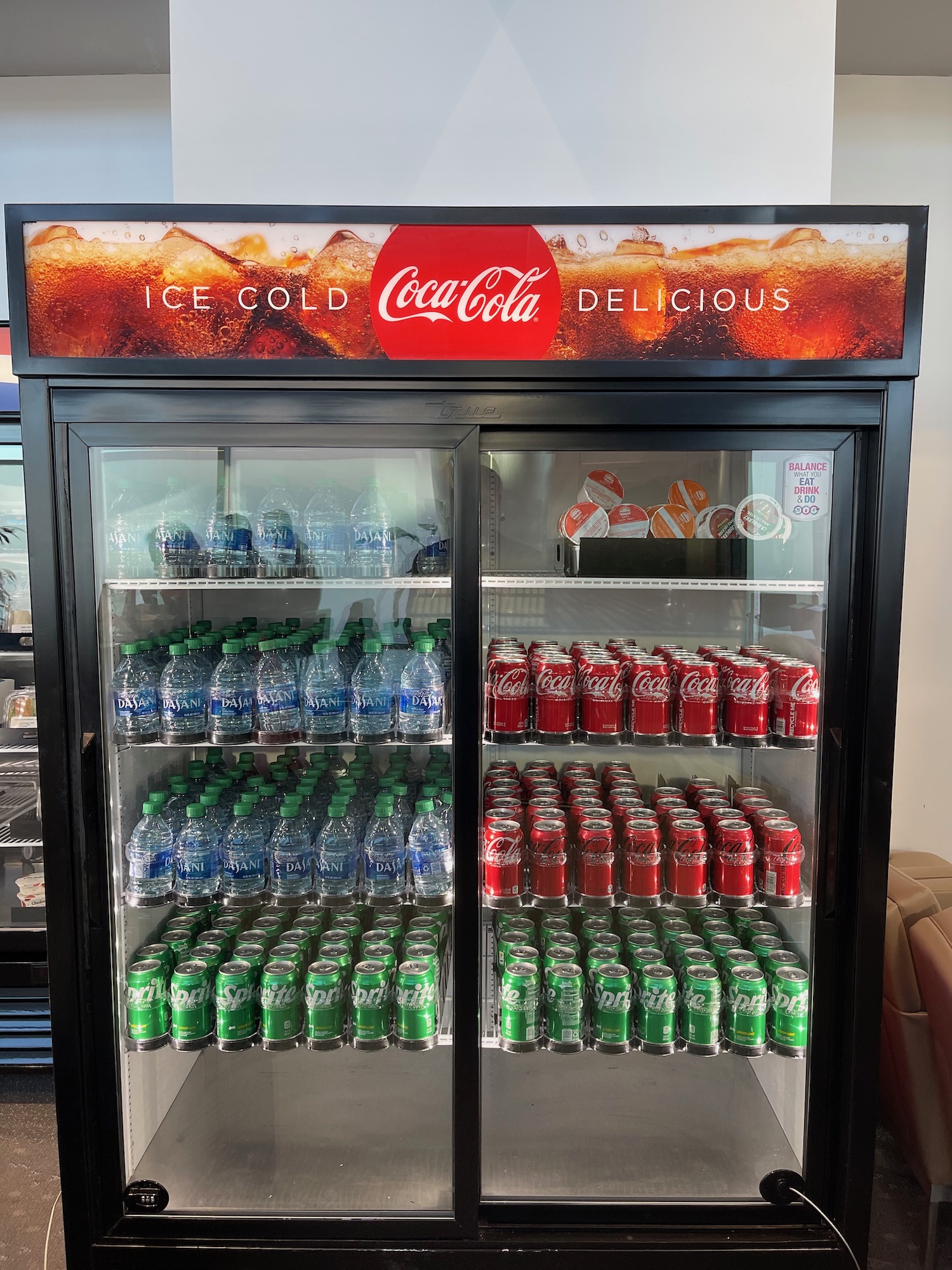 a display case with soda cans and bottles