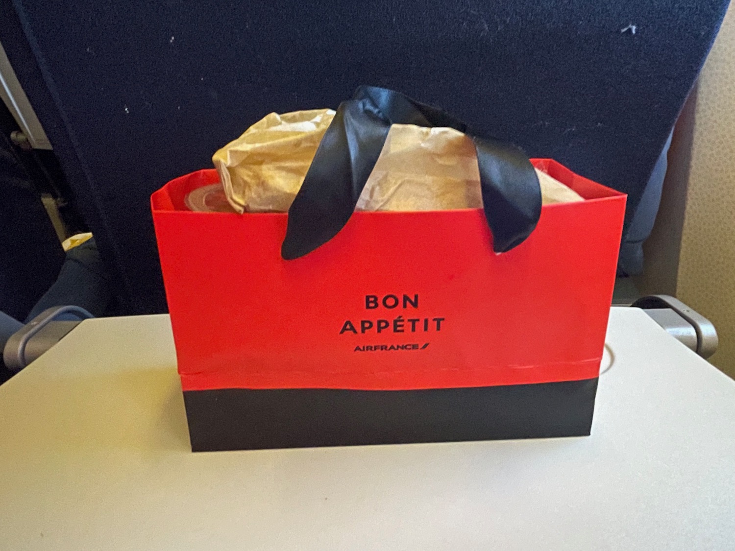 a red and black bag with a black ribbon on it