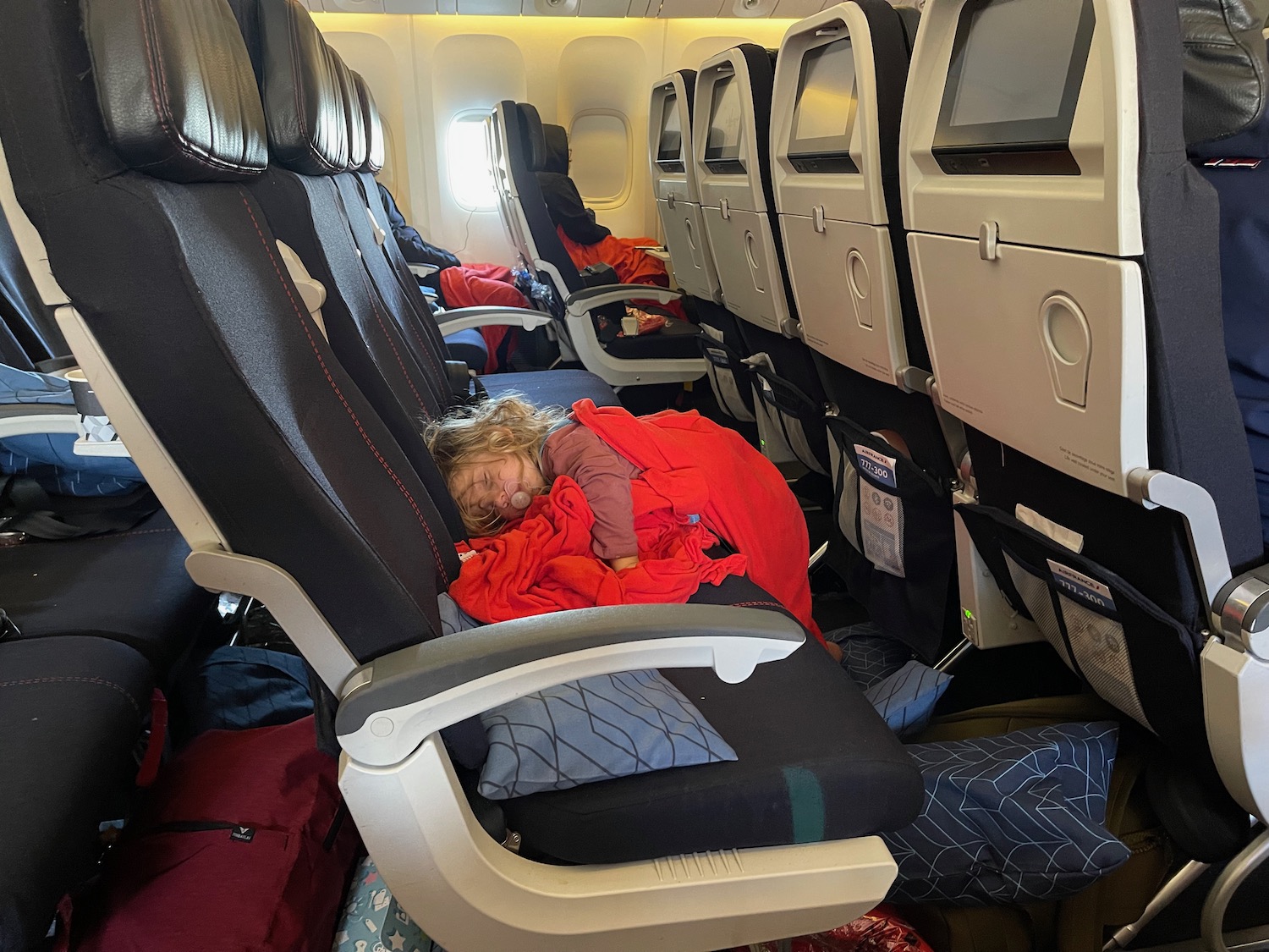 a child sleeping on an airplane seat