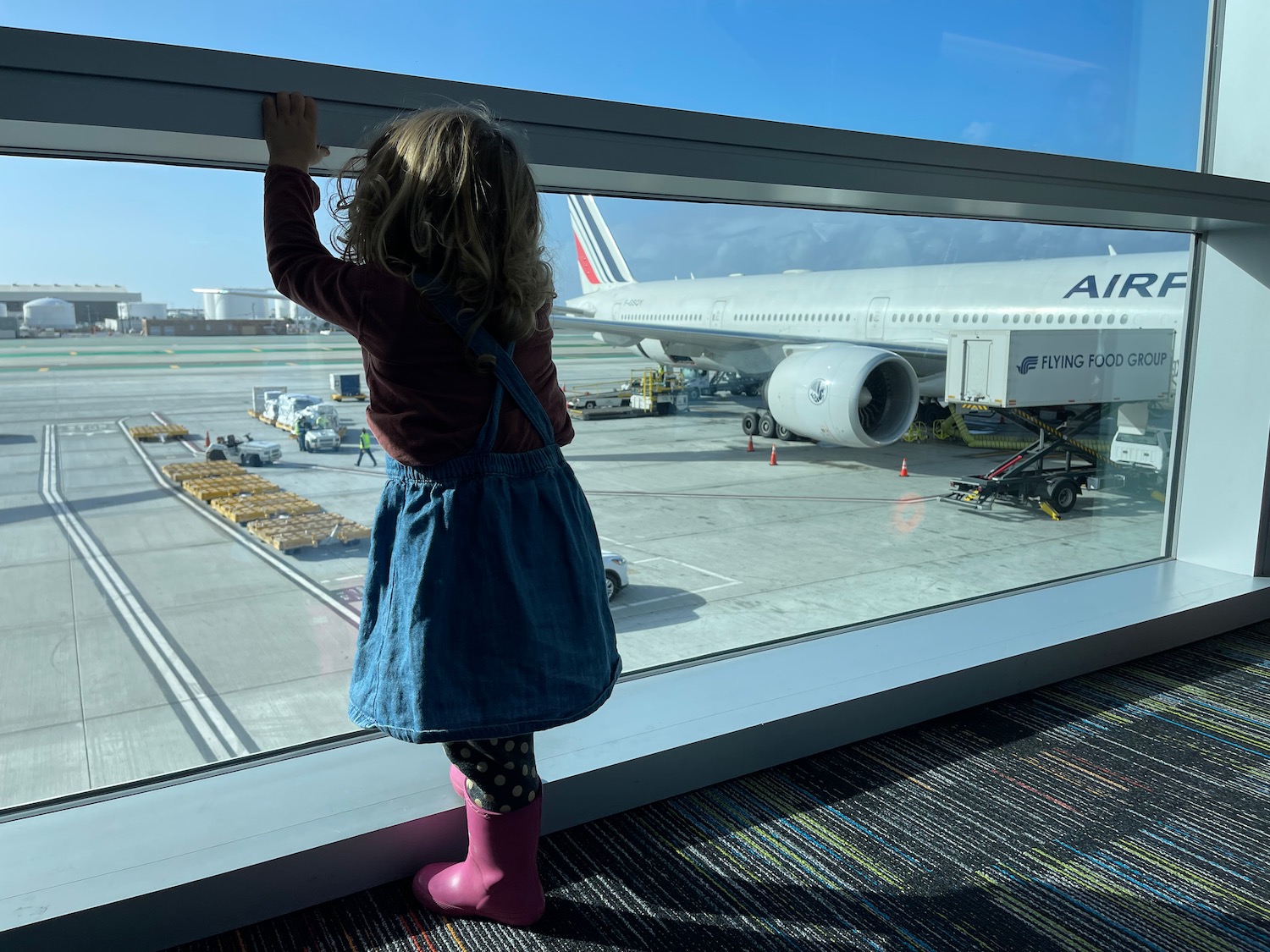 a child looking out a window at an airplane
