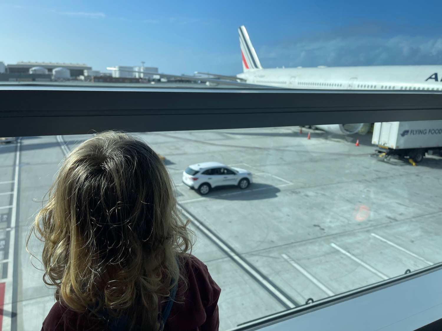 a woman looking out a window at an airplane