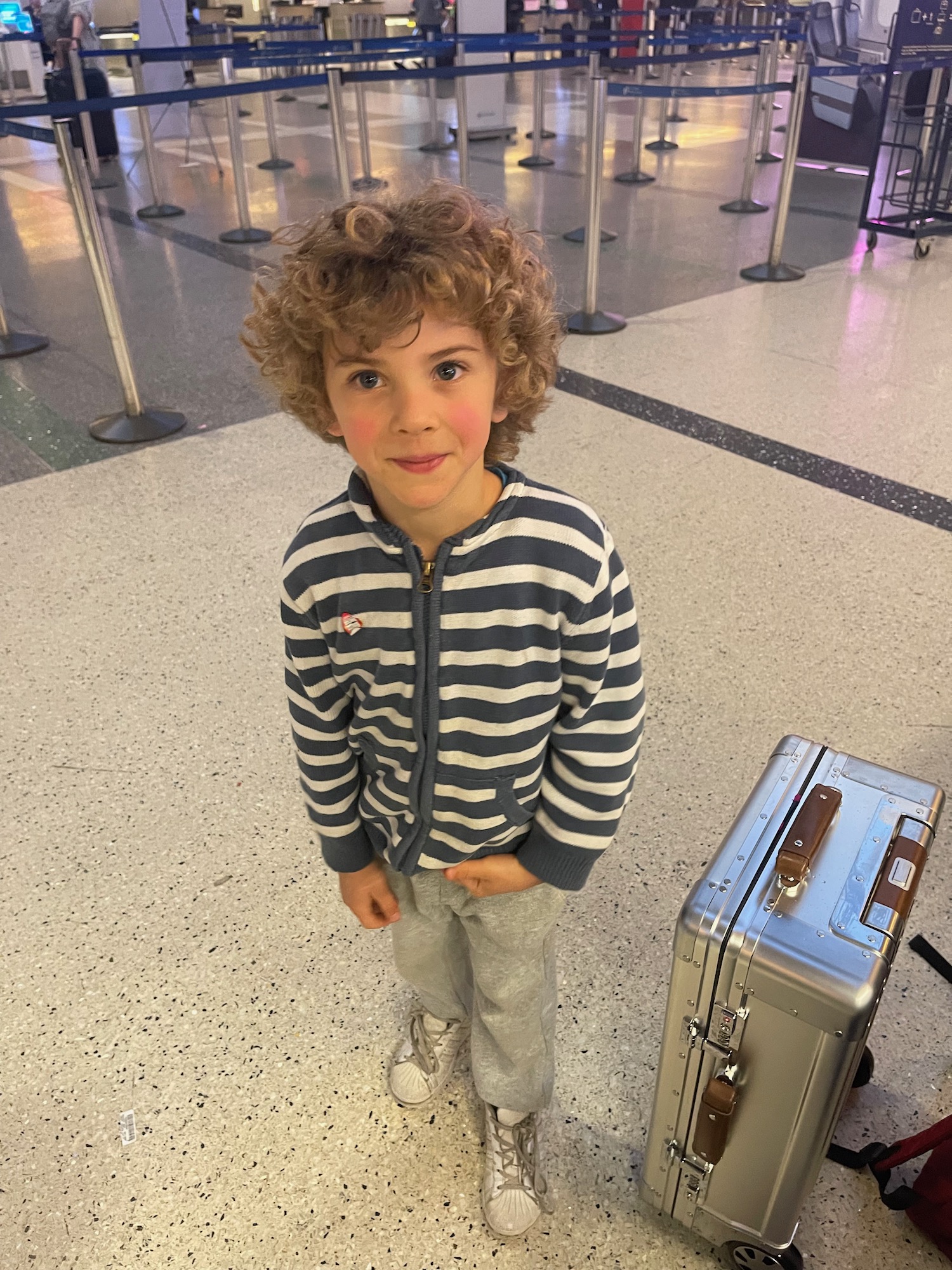 a boy standing in front of a suitcase