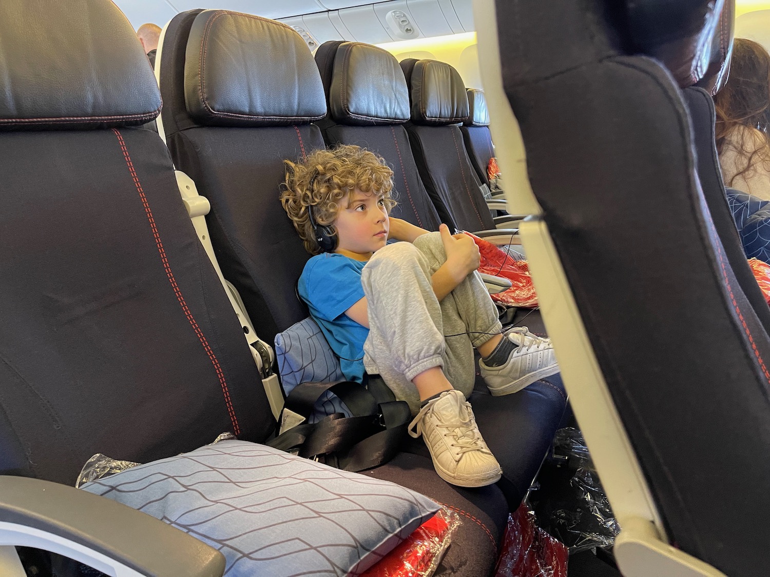 a boy sitting in a seat on an airplane