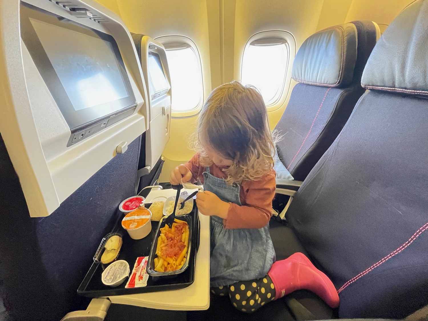 a child eating food on an airplane