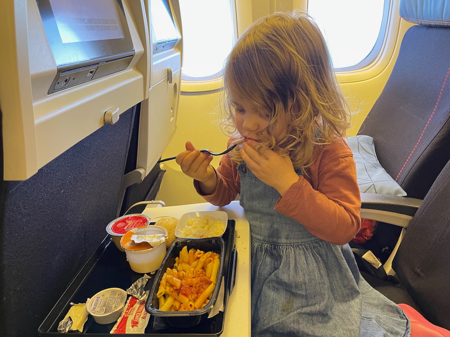 a girl eating food on an airplane