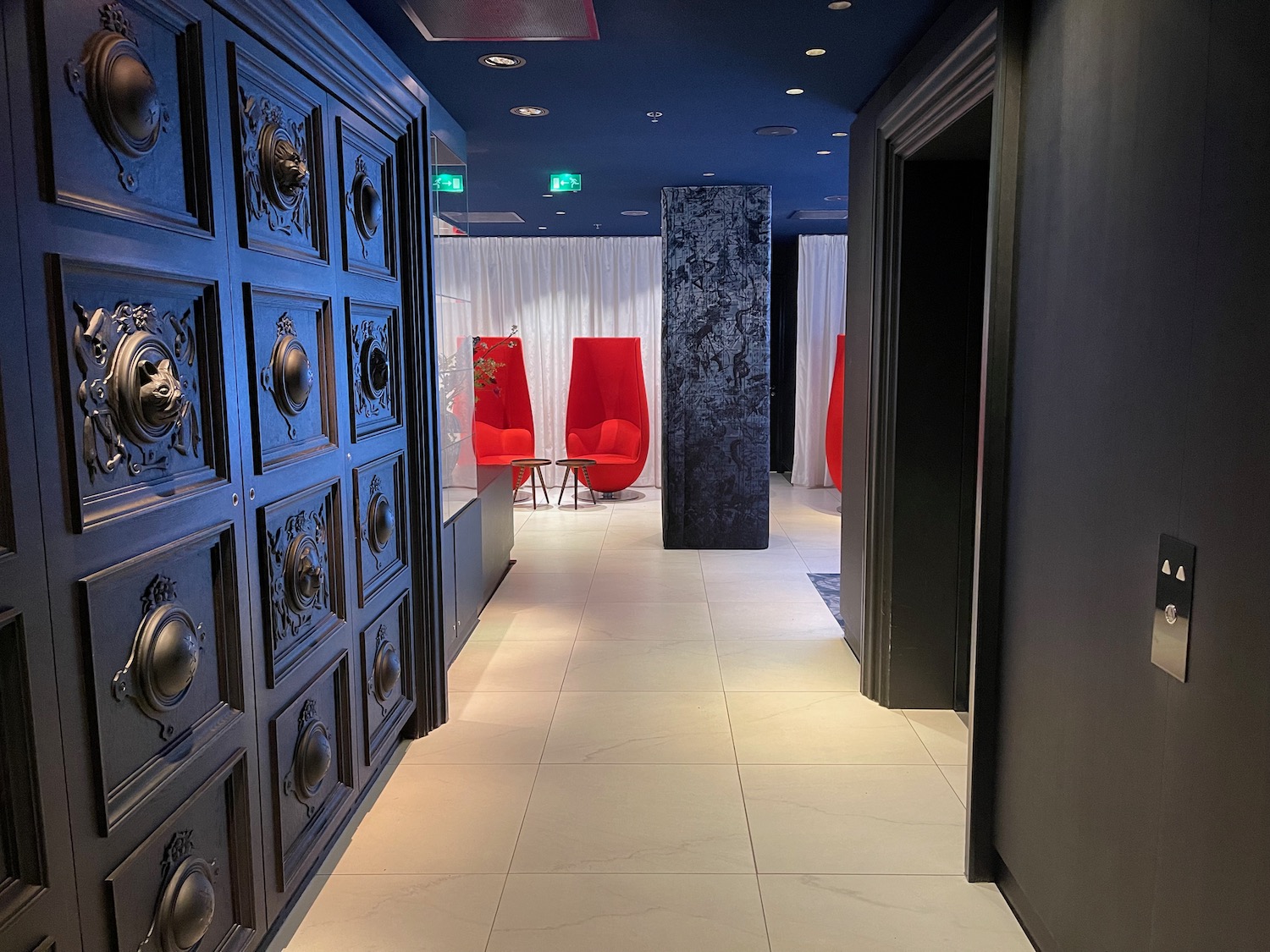 a hallway with red chairs and white curtains