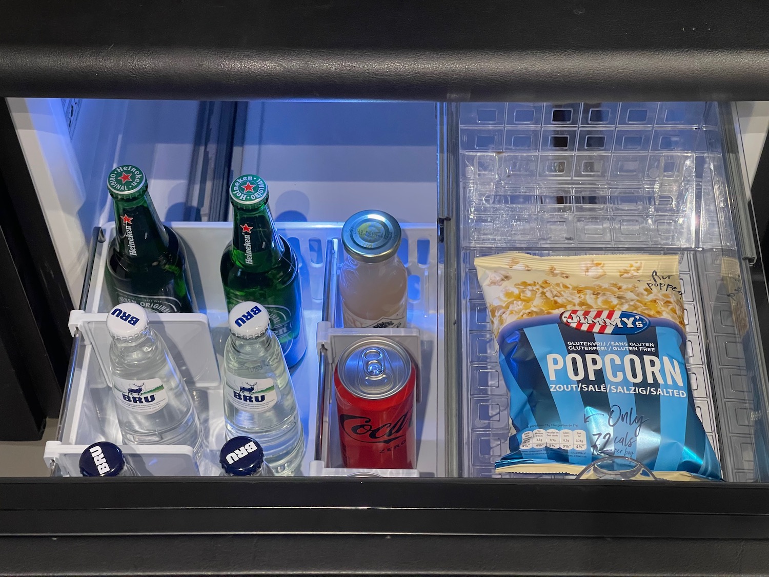 a refrigerator with bottles and snacks inside