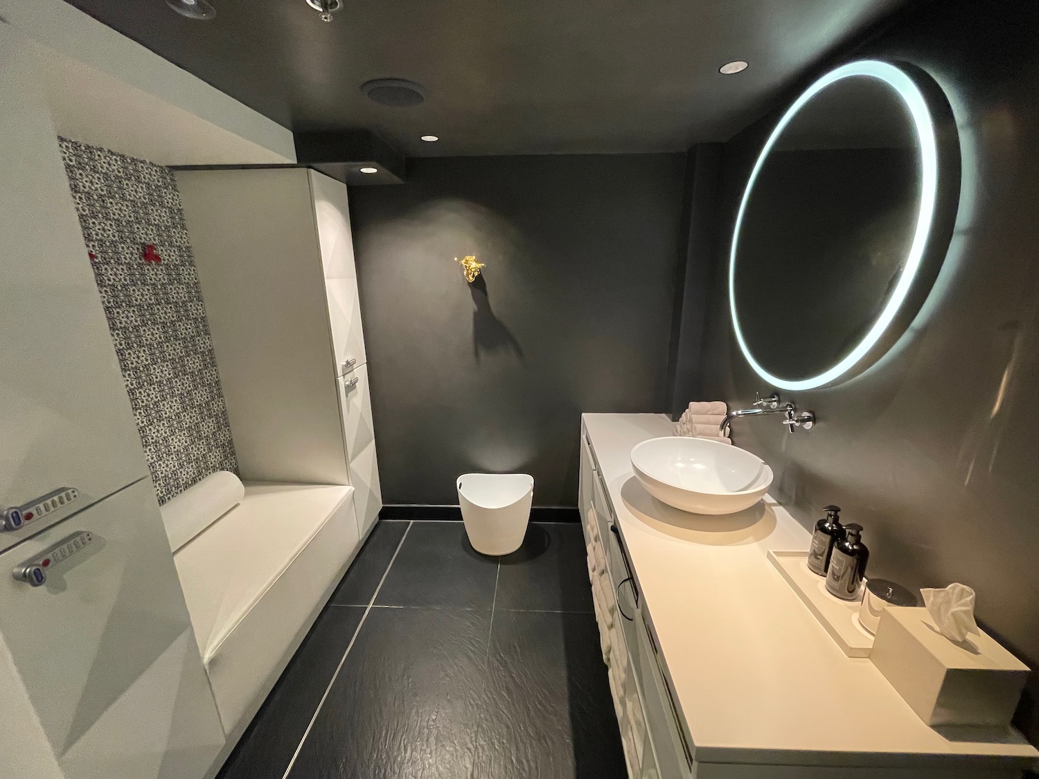 a bathroom with a round mirror and a sink