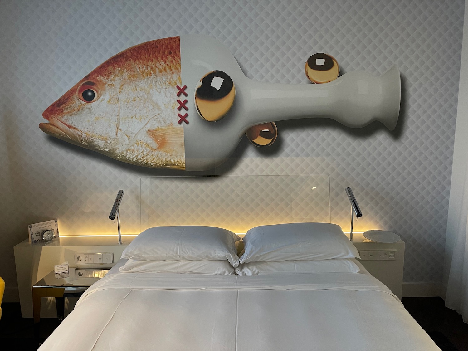 a bed with a fish on the wall